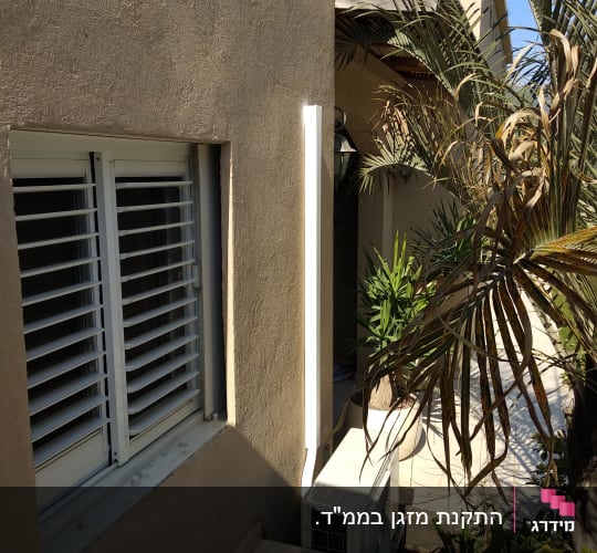 יחידת מזגן חיצונית מותקנת ליד קיר חיצוני